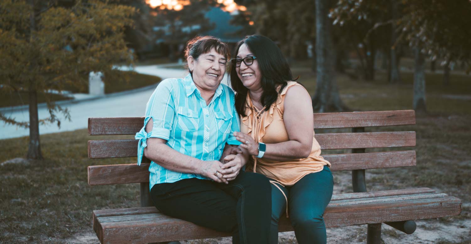 Two Women On A Bench Laughing
