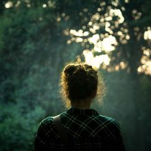 Woman in forest with back to camera